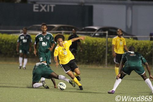 Photo: Teenaged playmaker Nathaniel Garcia (centre) dances through a crowd of W Connection players. (Courtesy Allan V. Crane/Wired868)