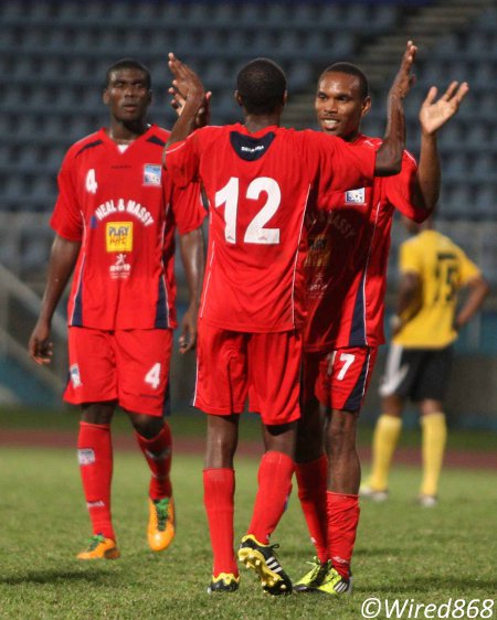 Photo: Caledonia right back Kareem Joseph (number 12) and midfielder Akim Armstrong exchange pleasantries. (Courtesy Wired868)