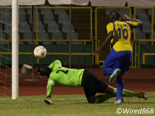 Photo: North East Stars custodian Cleon John makes a fantastic save from Defence Force striker Devorn Jorsling (right). (Courtesy Wired868)