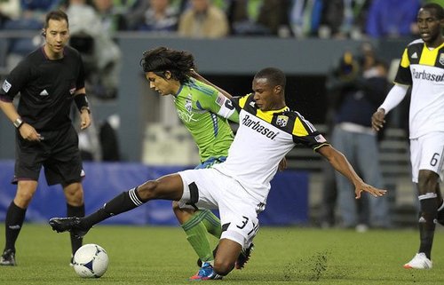 Photo: Columbus Crew midfielder Kevan George (right) tackles Seattle Sounders attacker Fredy Montero.