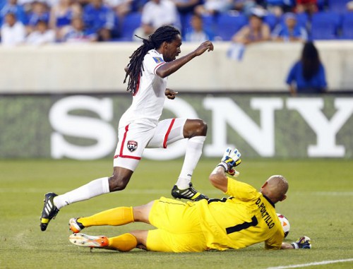 Photo: Trinidad and Tobago midfielder Keon Daniel goes around El Salvador goalkeeper Dagoberto Portillo. (Courtesy YahooSports)