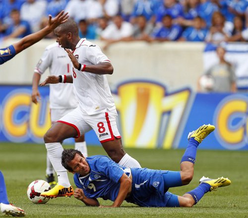 Photo: Trinidad and Tobago midfielder Khaleem Hyland (centre) knocks El Salvador forward Rafael Burgos off the ball. Hyland was a combination of strength and composure for the "Soca Warriors."