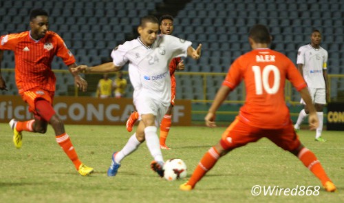 Photo: W Connection right back Joao Ananias (centre) tries to play his way out of trouble while Houston Dynamo players Jason Johnson (left) and Alexander Lopez look on. (Courtesy Wired868)