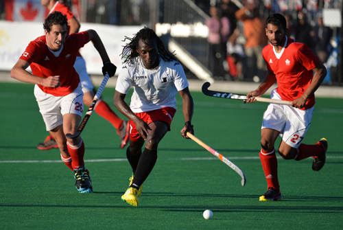 Photo: Trinidad and Tobago star Kwan Browne (centre) glides through the Canada defence. (Courtesy Panamhockey.org)